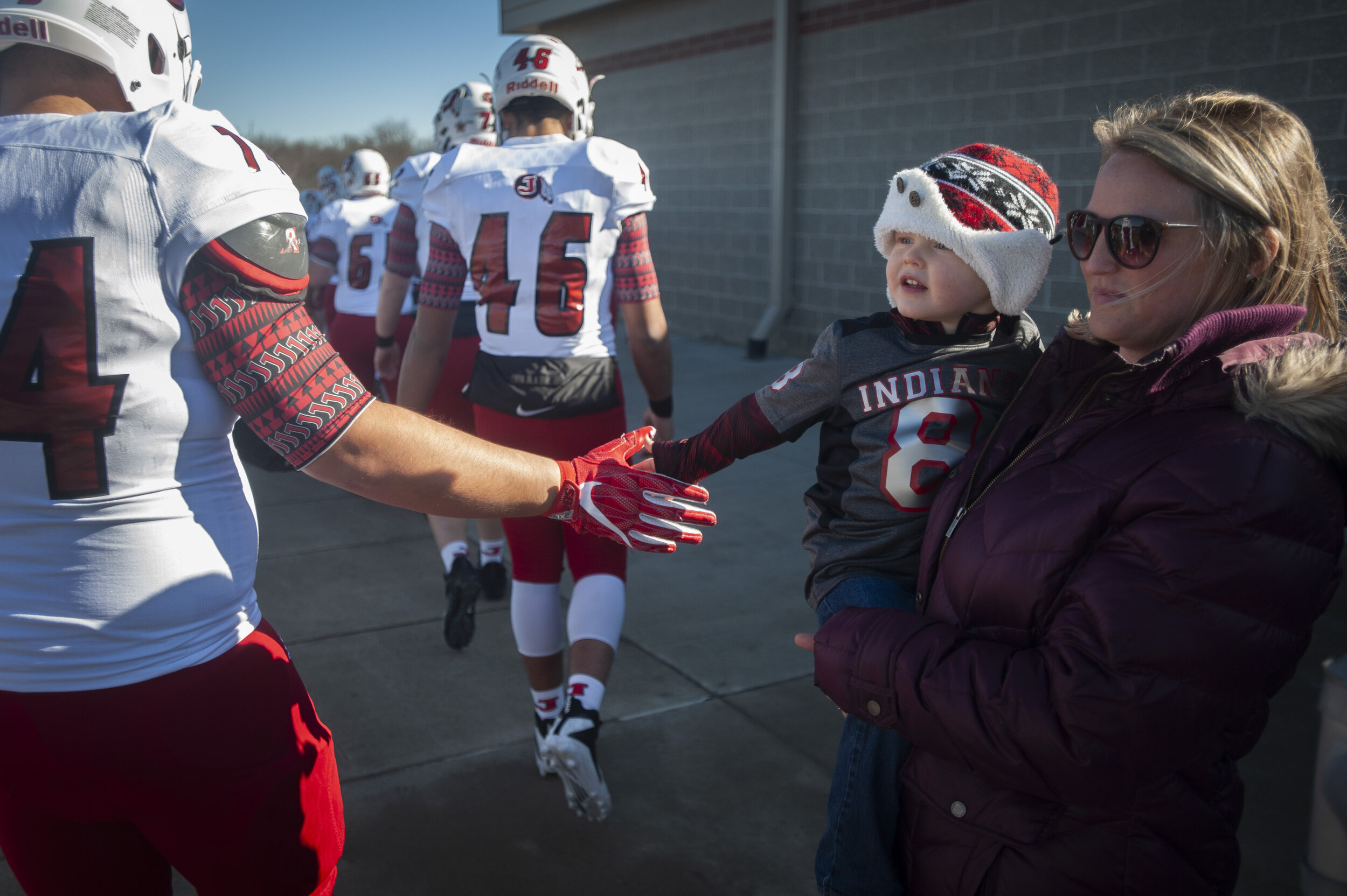 While held by his mother Jessica Bardot of Jackson, Liam Bardot, 3, high fives Jackson's Noah Gibson (74) before the Jackson Indians' 20-7 victory over Staley High School in the MSHSAA Class 5 state semifinals Saturday, Nov. 30, 2019, in Kansas City