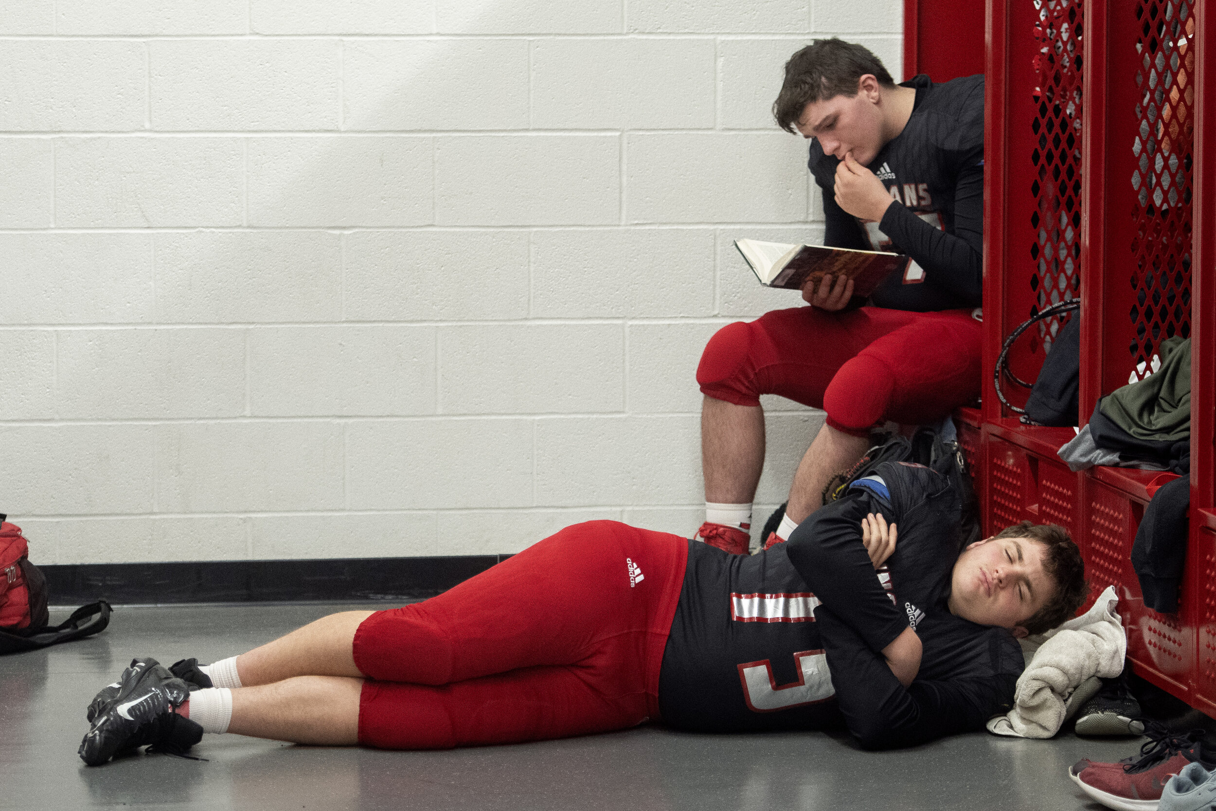  Jackson's Mark Brakhane (75) lies on the floor while Luke Brotherton (57) reads a book before the Jackson Indians' 49-20 win against the Fox Warriors in the Class 5 District 1 championship Friday, Nov. 15, 2019, in Jackson.  