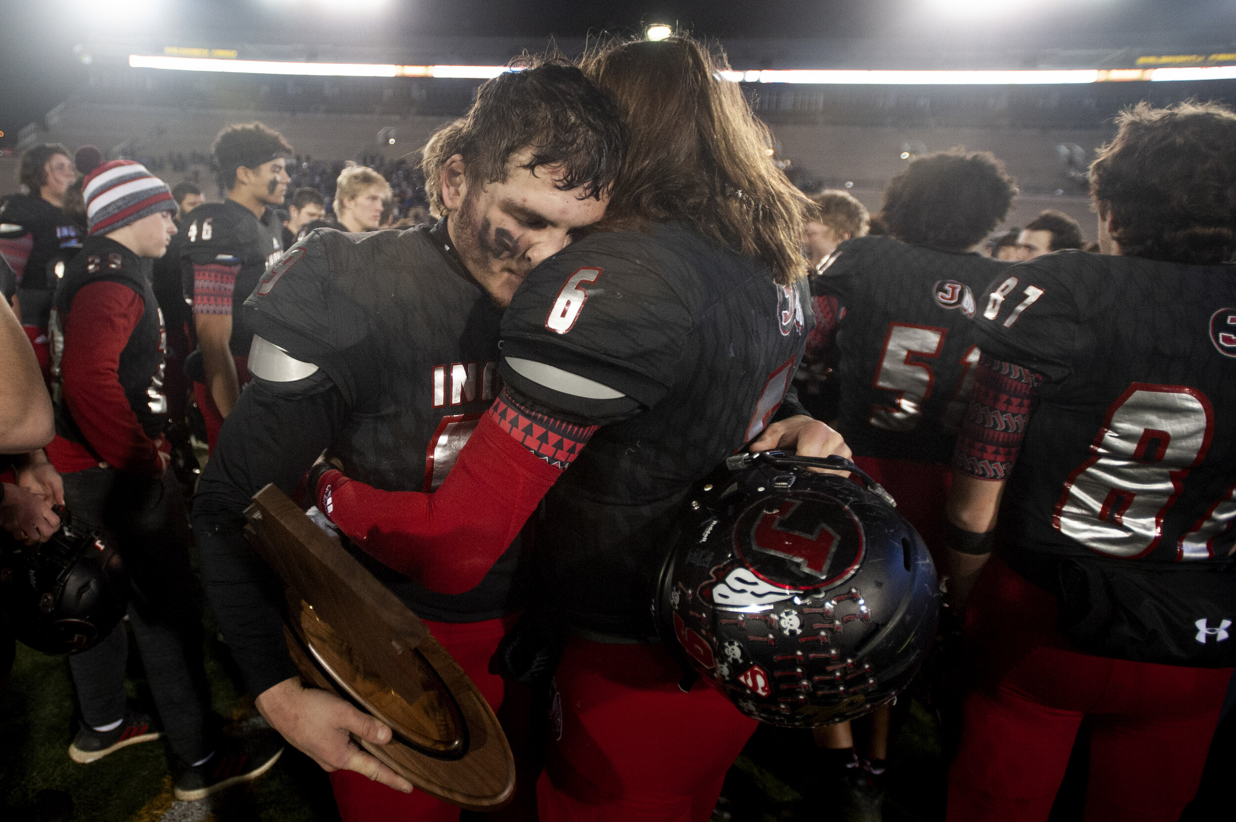  Jackson's Cael Welker (6) and Cole Amelunke (99), holding the Indians' second place trophy, hug following the team's 27-21 overtime loss to Carthage in the MSHSAA Class 5 state championship Saturday, Dec. 7, 2019, at Faurot Field in Columbia, Missou