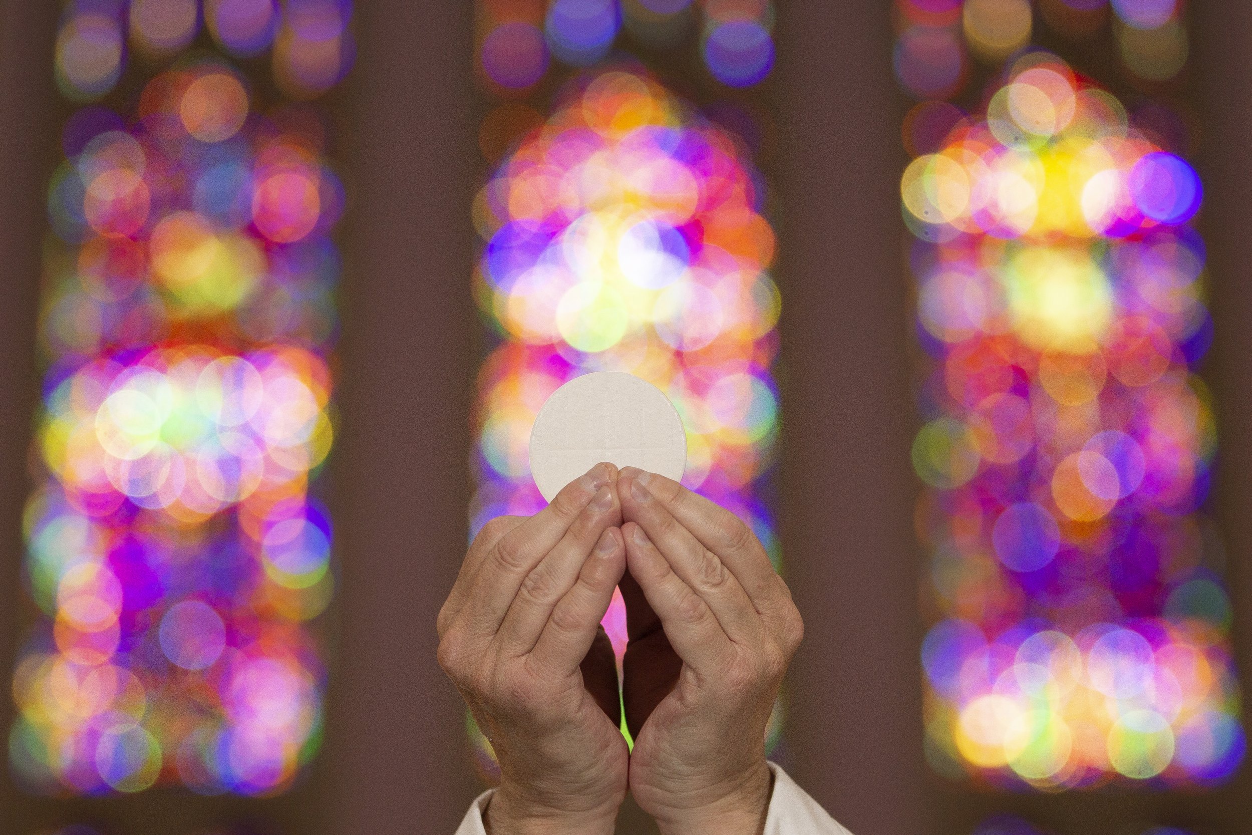  In this photo illustration, the Eucharist was depicted using an unconsecrated host held by Father Nicholas Smith on April 21 at St. Vincent de Paul Chapel in the Cardinal Rigali Center in Shrewsbury, Missouri.  