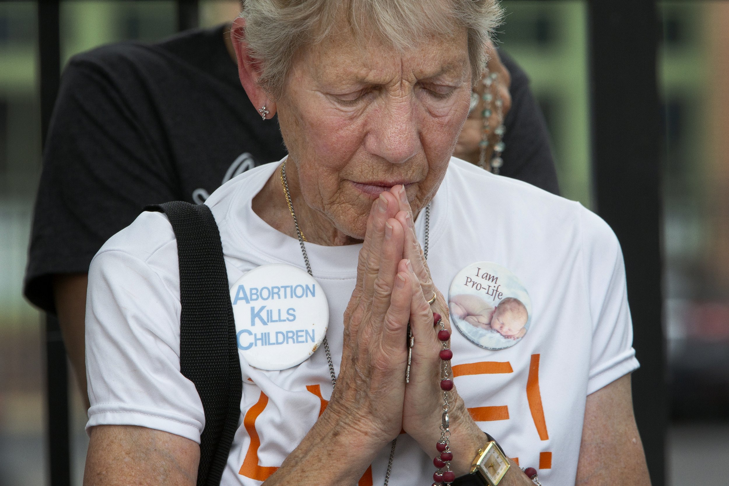  Rita Sparrow, a parishioner at St. Elizabeth Ann Seton Parish in St. Charles, folded hands as a priest spoke during a gathering June 24 outside Planned Parenthood in St. Louis, Missouri. Earlier in the day, the Supreme Court released its decision in