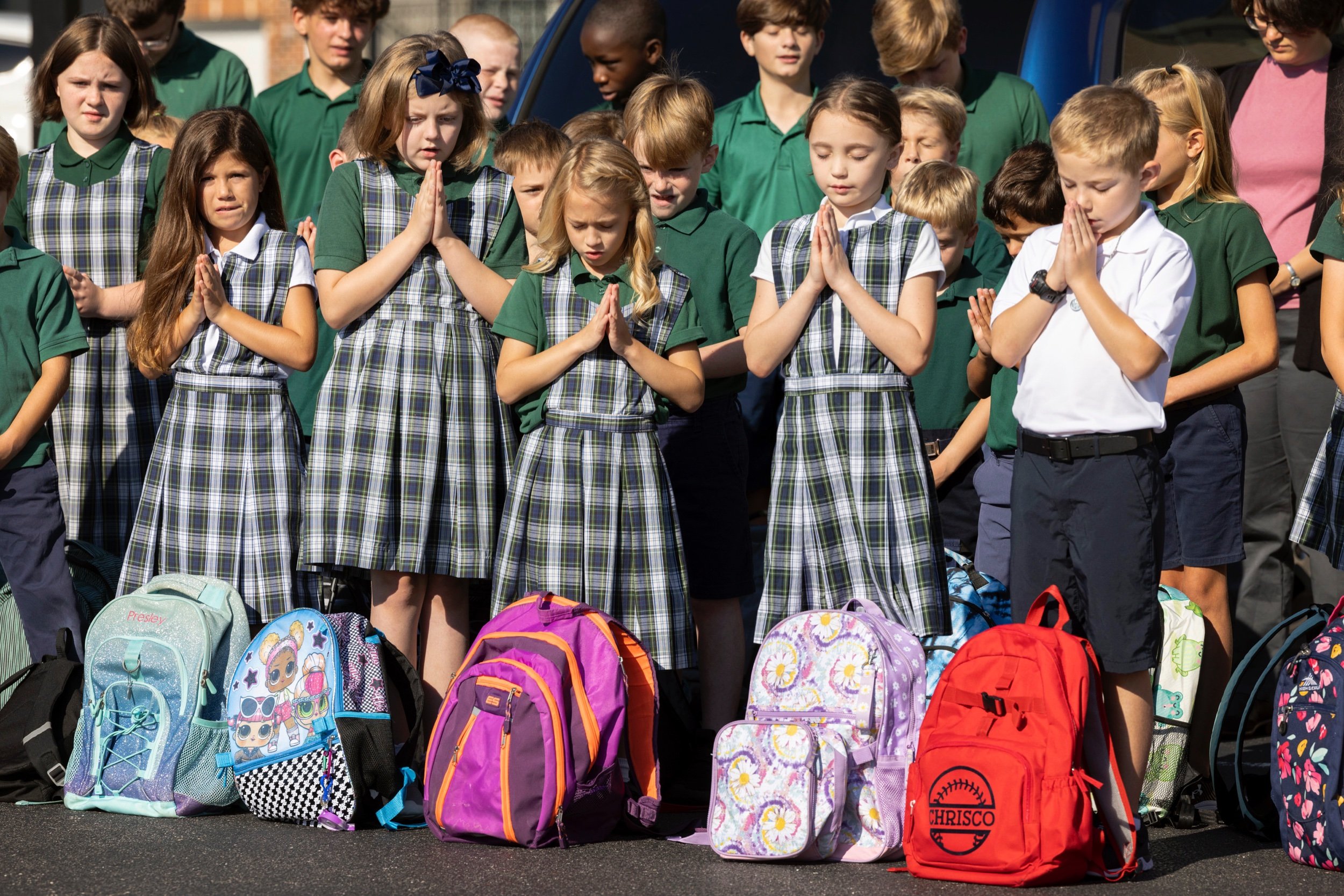  Students, with backpacks ready to be blessed by Father Daniel G. Shaughnessy, folded their hands in prayer on the first day of school Aug. 17 at Saint Joseph School in Imperial, Missouri. 