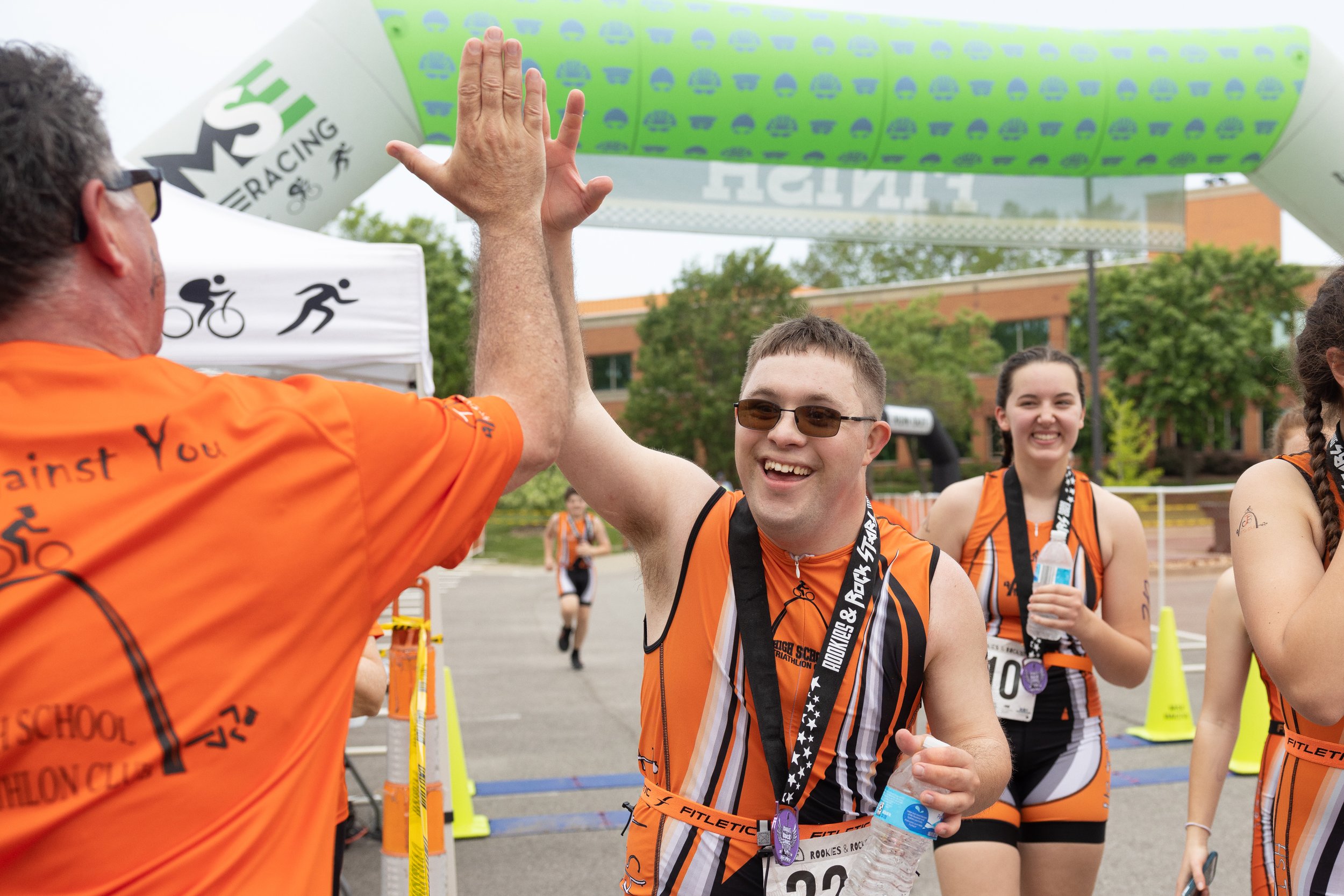  Gabriel gave his father, Thomas Cobb, a high five while going through the finish line with members of the High School Triathlon Club on May 7 at St. Peters Rec-Plex. Club members run through the finish line together with the last member of the club 