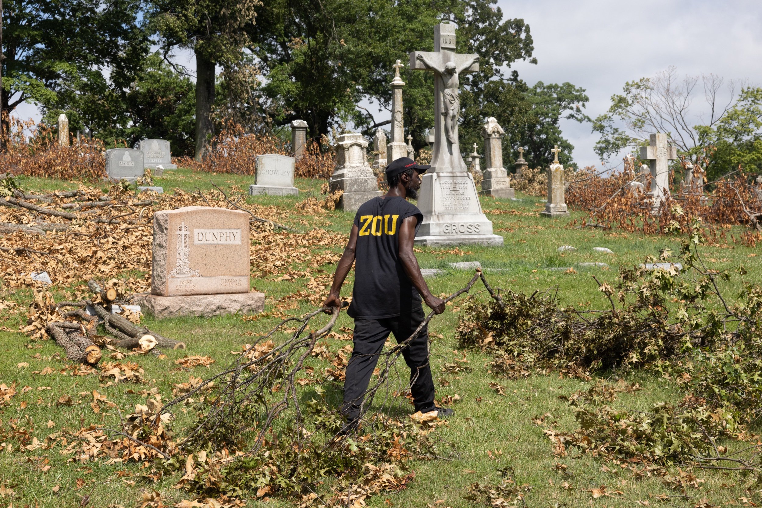  Daniel Tyler of St. Louis cleared debris from storm damage July 13 at Calvary Cemetery in St. Louis. The cemetery was damaged during storms the weekend of July 1 and is currently closed to the public due to the damage. 