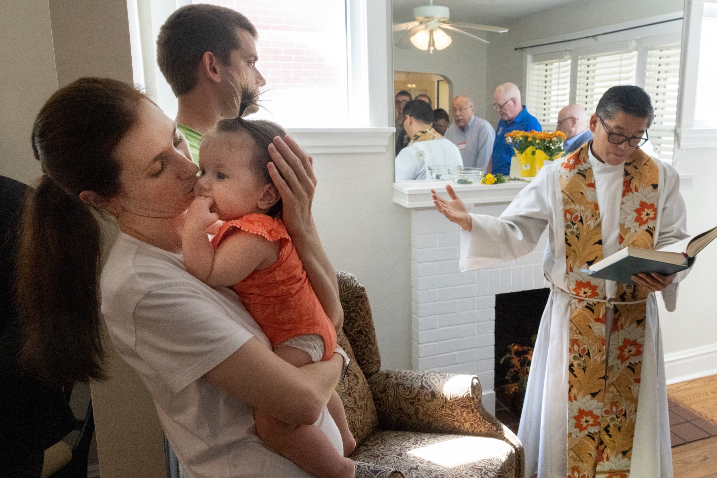  Ukrainian refugee Zina Tkachenko held her 7-month-old daughter, Mia, as Father Toshio Sato, CM, spoke at a blessing of St. Michael House, the family’s new home, Sept. 29 in south St. Louis. Zina and her husband, Serhii, along with their two children