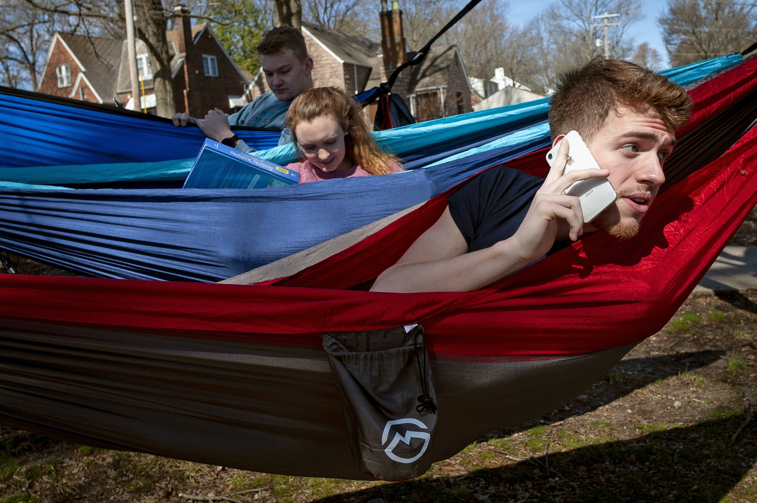  David Dugan of Charleston, Missouri, speaks on the phone with Ashley Freese of St. Louis, Missouri, who was about the join the hammocking group of Southeast Missouri State University students including Harley Allen of Dexter, Missouri, (middle) and 