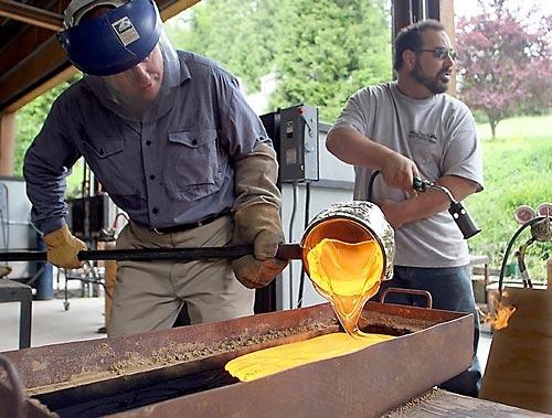 Jeremy Popelka pouring glass into a sand mold at Pilchuk in 2005, photo courtesy of the Seattle Times.