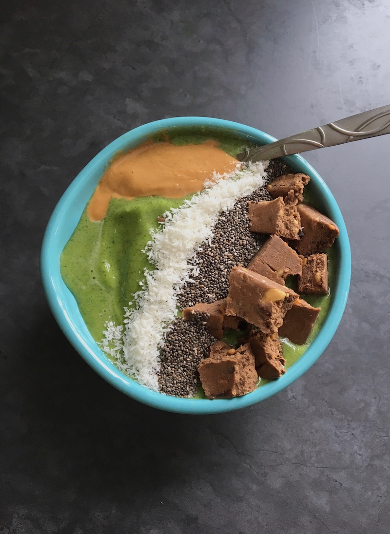Green smoothie bowls topped with cashew butter, coconut flakes, chia seeds, and a Perfect Bar