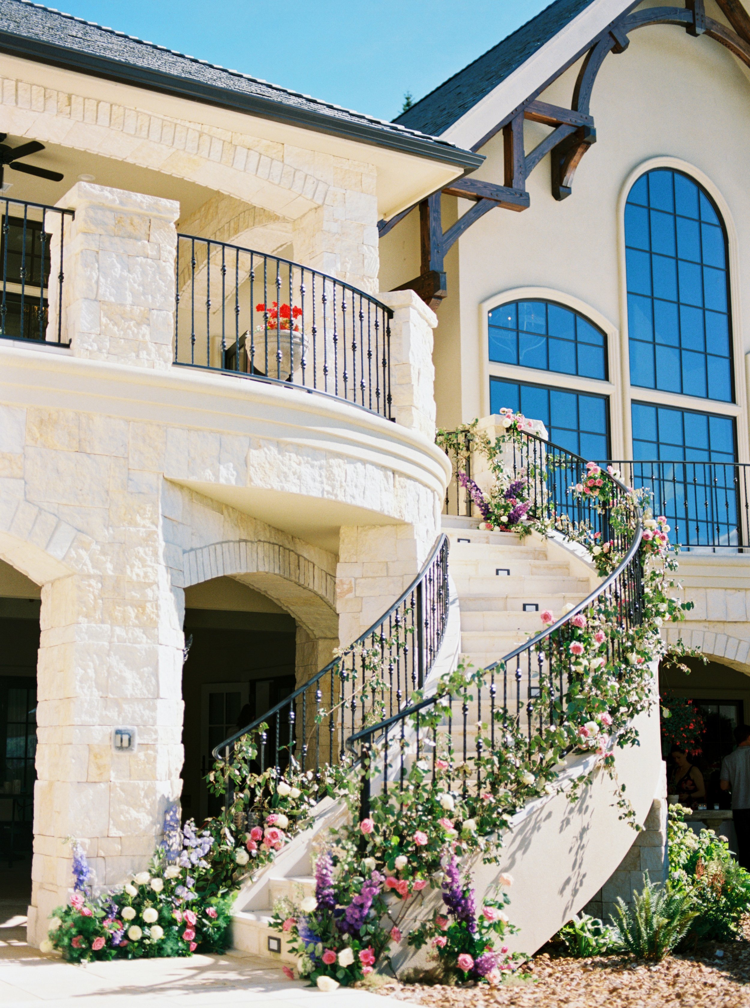 Flowers decorating a wraparound outdoor staircase at an Oregon wedding venue.