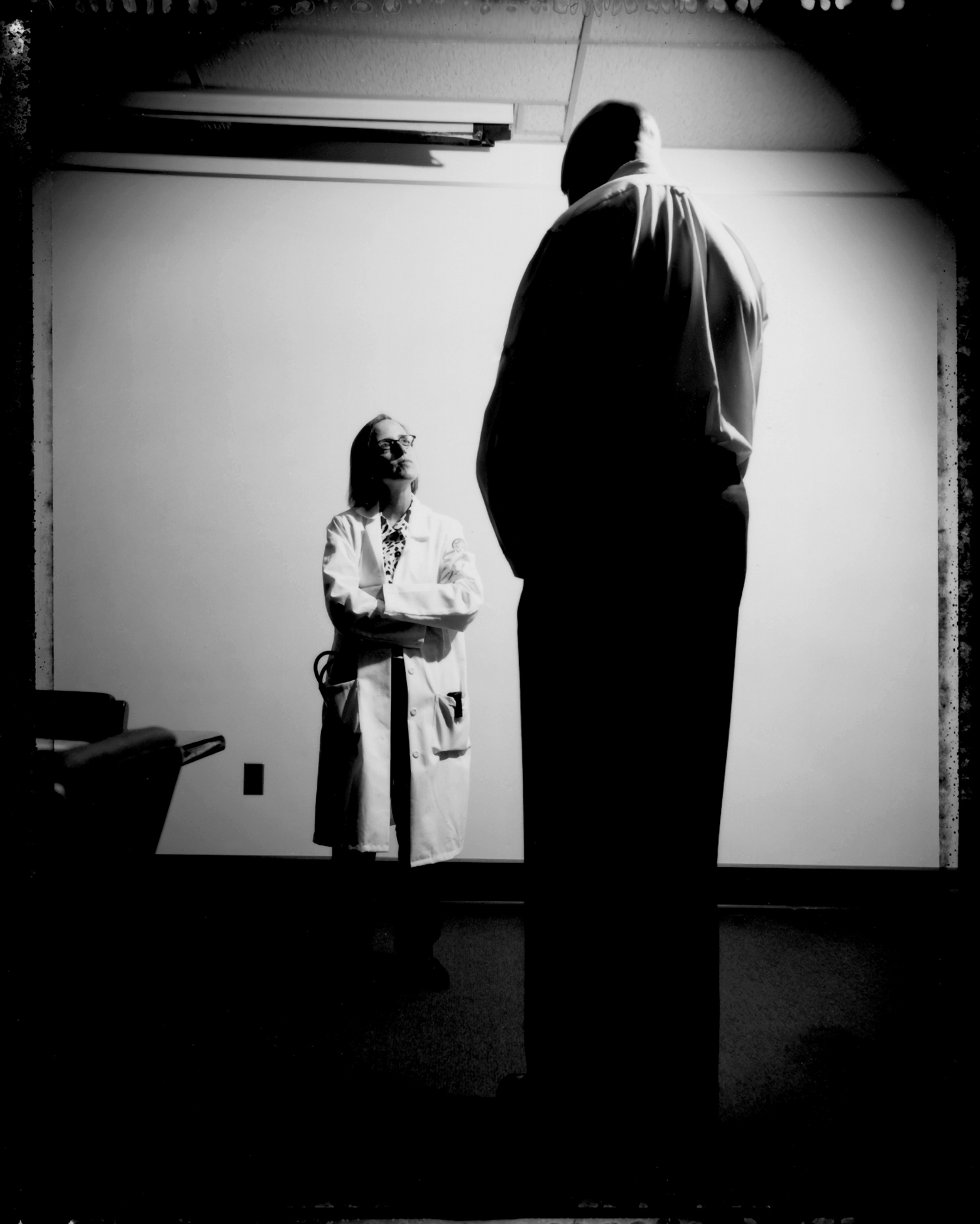 A cardiologist and her patient, a man with Marfans Syndrome. In Marfans, genetic connective tissue disorder, the Aorta, the main vessel that leaves the heart, is enlarged, which can be life threatening. Among, the other most common and readily seen signs and symptoms, these individuals are tall, skinny, with long arms, big hands, and long fingers. 