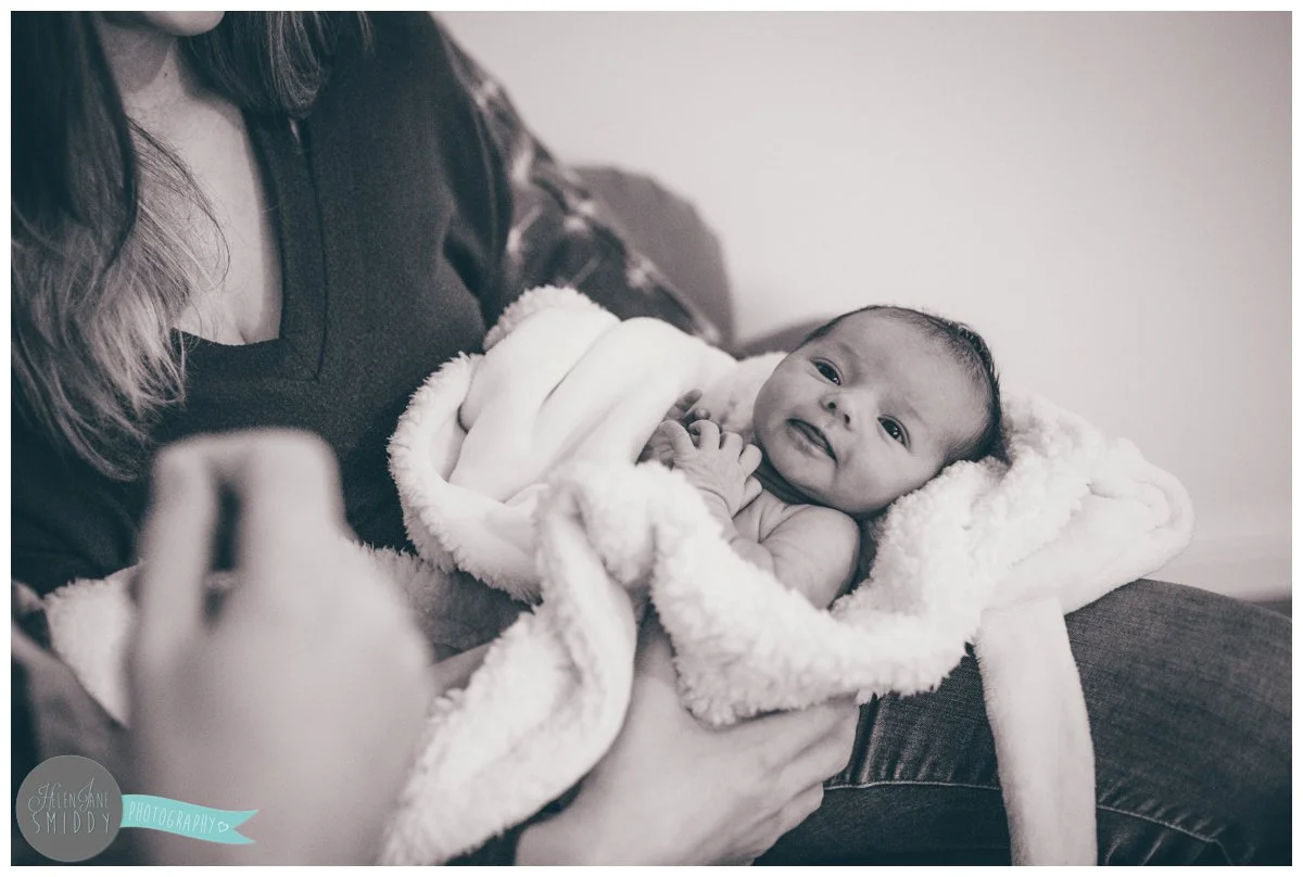 Close-up of a newborn baby girl being held by her mum and dad.