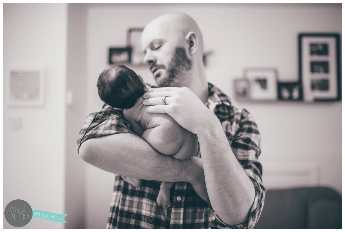 New dad holds his naked daughter after her bath.