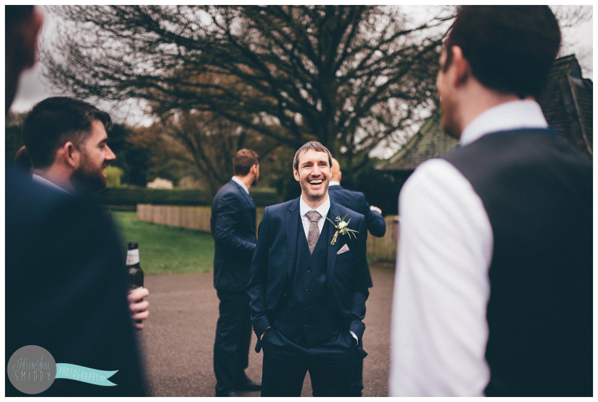 One of the Groom's friends laughs in conversation before the wedding ceremony.