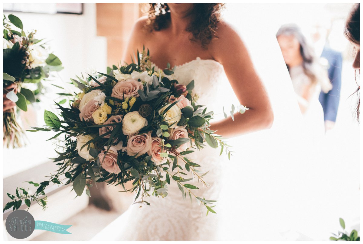 The bride holds her stunning bouquet whilst she wait to enter the church.