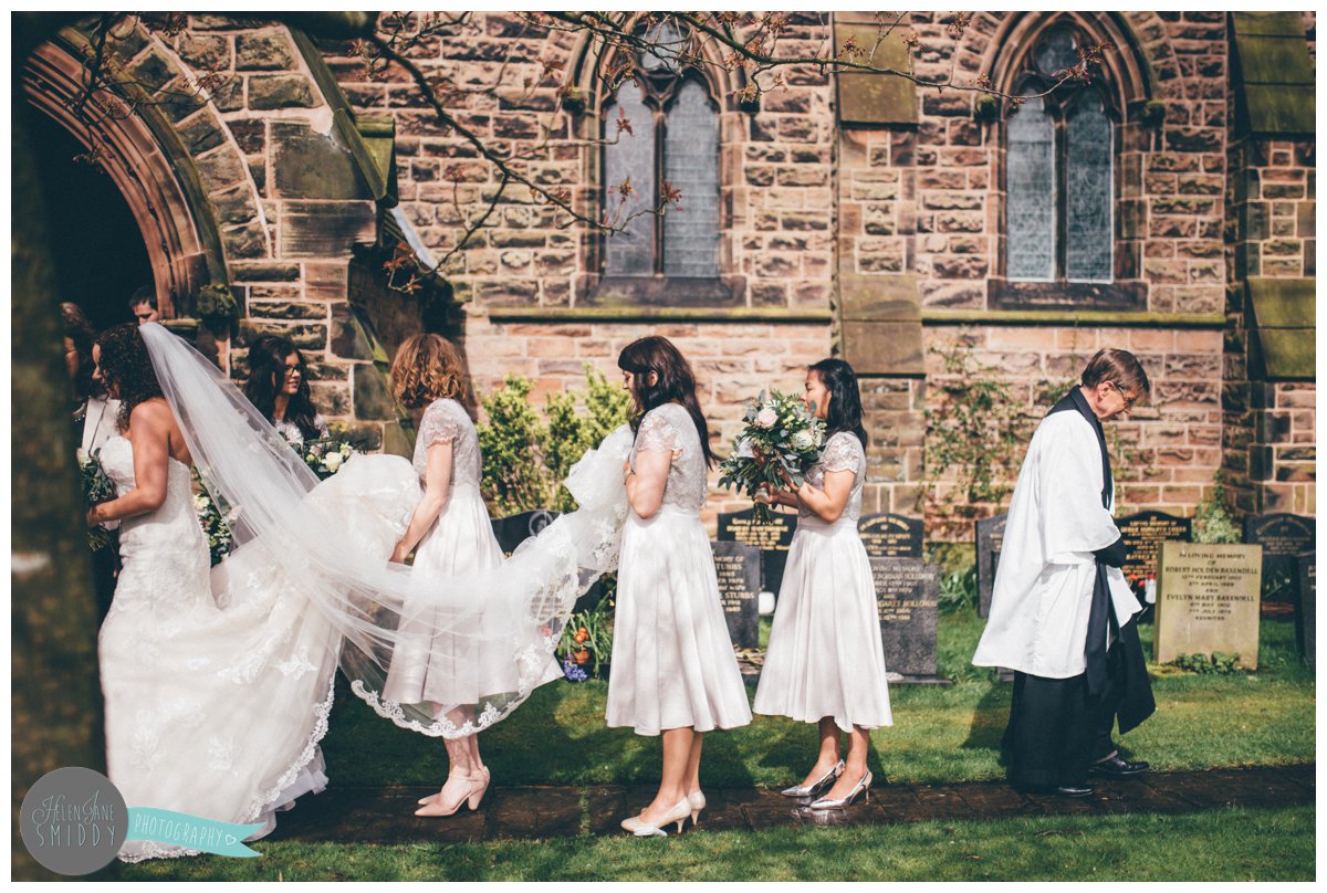 The vicar walks away from the bridal party after the wedding ceremony at Toft Church in Knutsford.