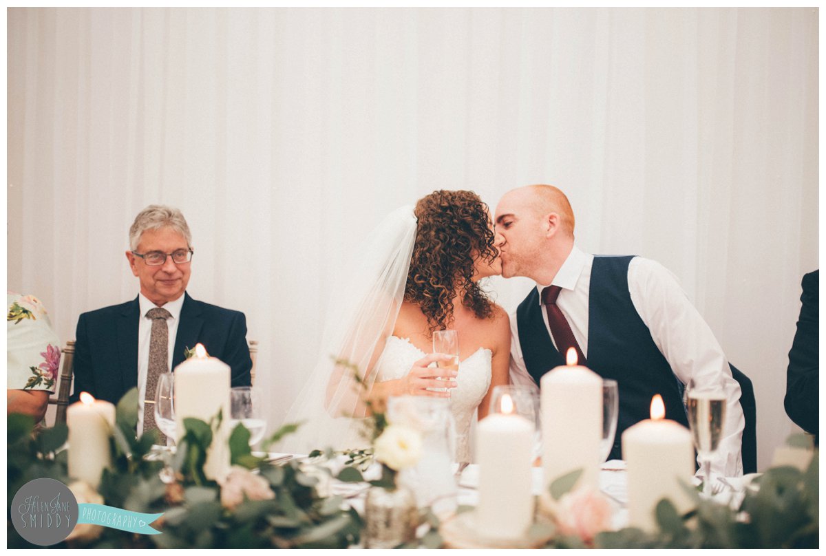 The bride and groom share a kiss after his speech.