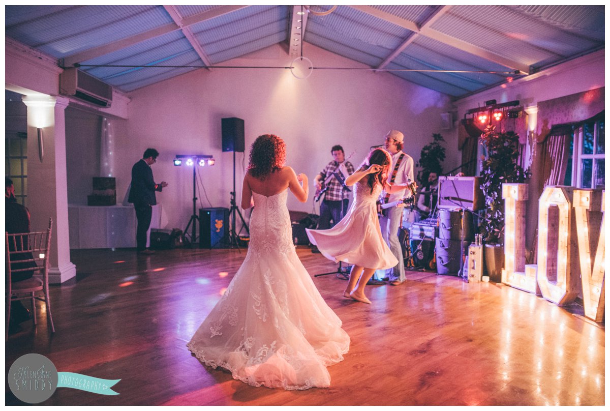 The bride dances with her best friend and maid of honour as soon as the band starts.