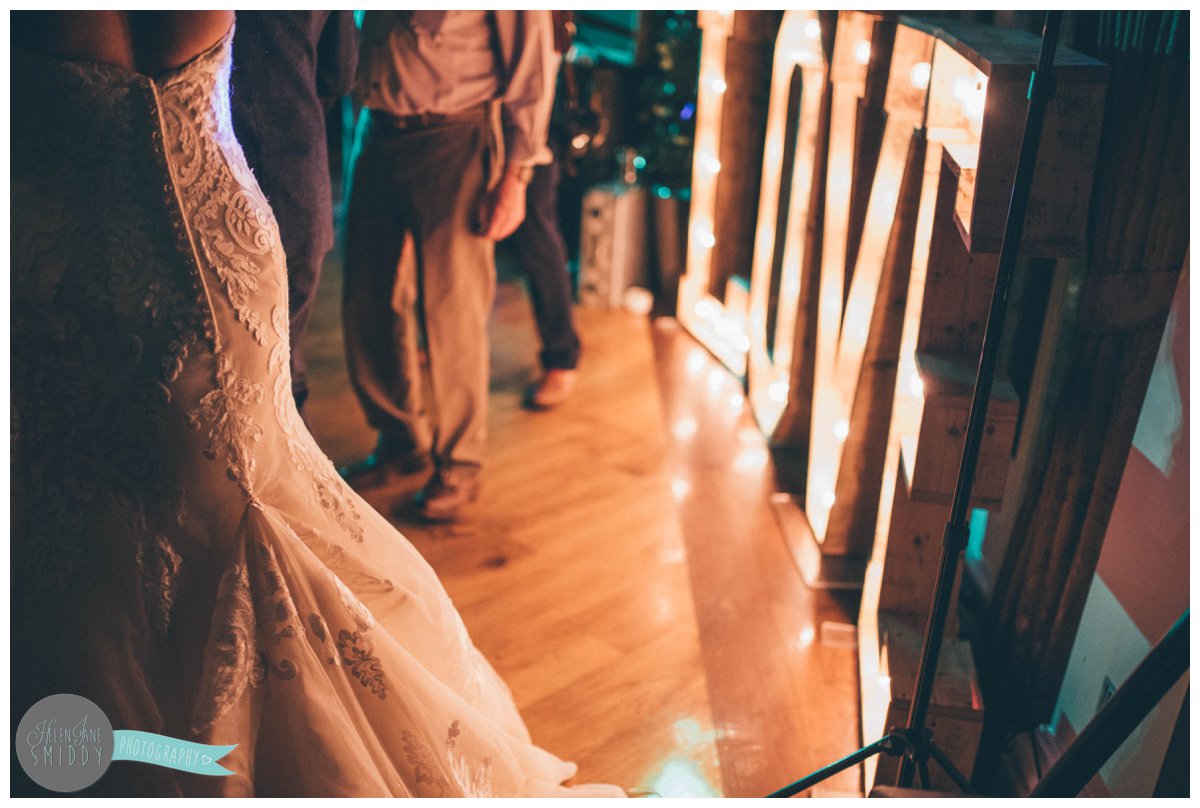 The bride's gown is lit up by the beautiful "love" sign.