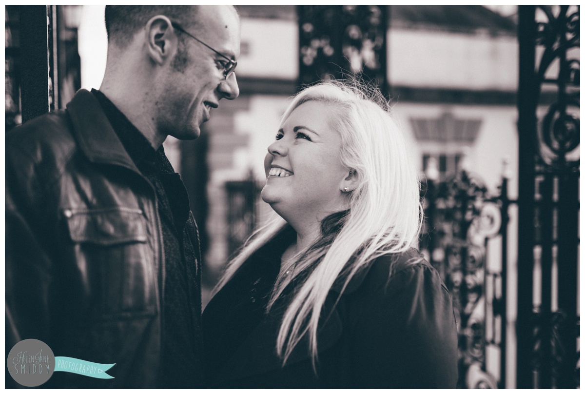 Close-up photograph of engaged couple underneath the Eastgate Clock in Chester, Cheshire.