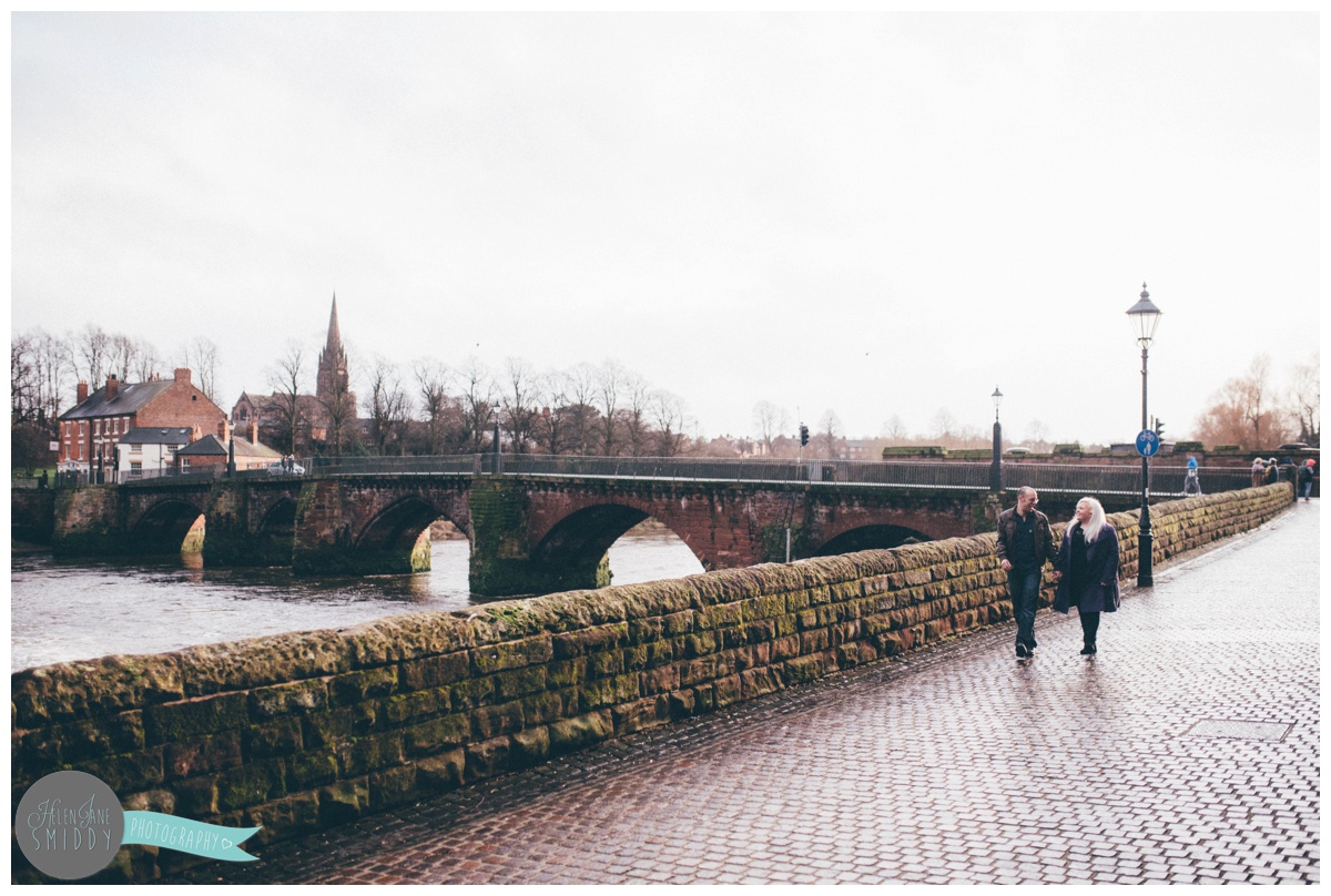 Joanna and Alan stroll, hand-in-hand along the River Dee in Chester, Cheshire for their pre-wedding shoot.