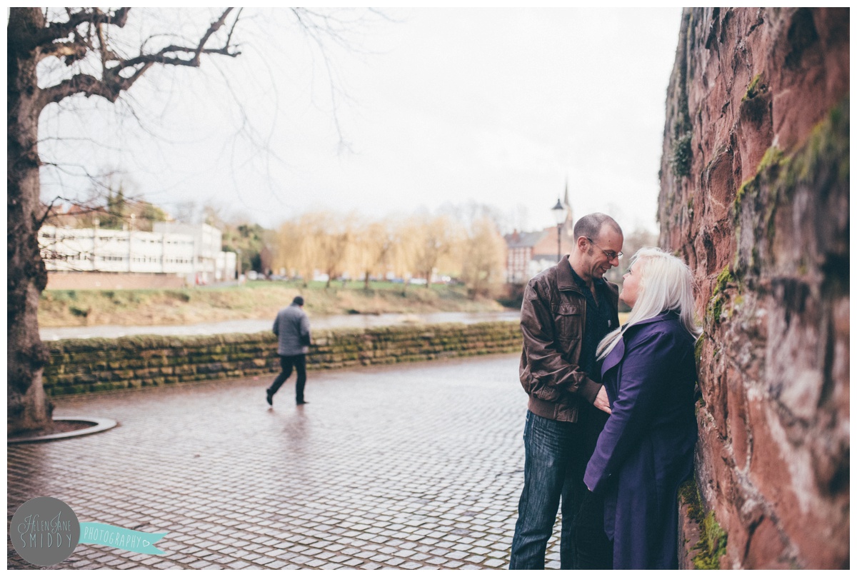 The couple stand against part of the old Roman walls next to the River Dee during their Engagement Shoot in Chester.