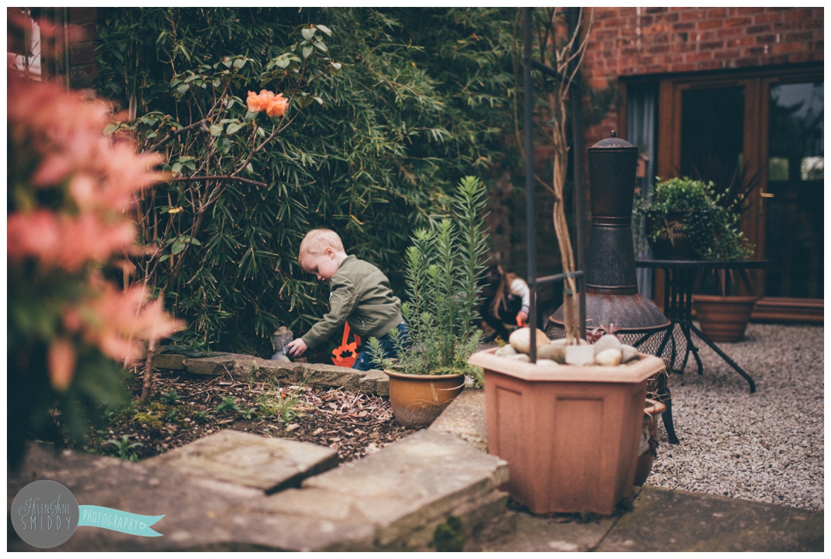 Brother and sister look through their grandparents garden for Easter eggs.