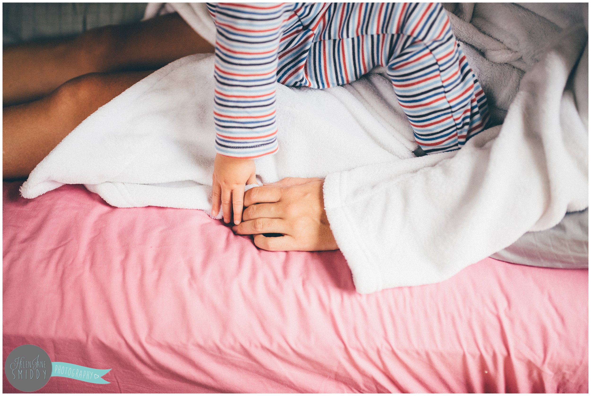 Close-up photograph of Zoe holding hands with her Mummy.