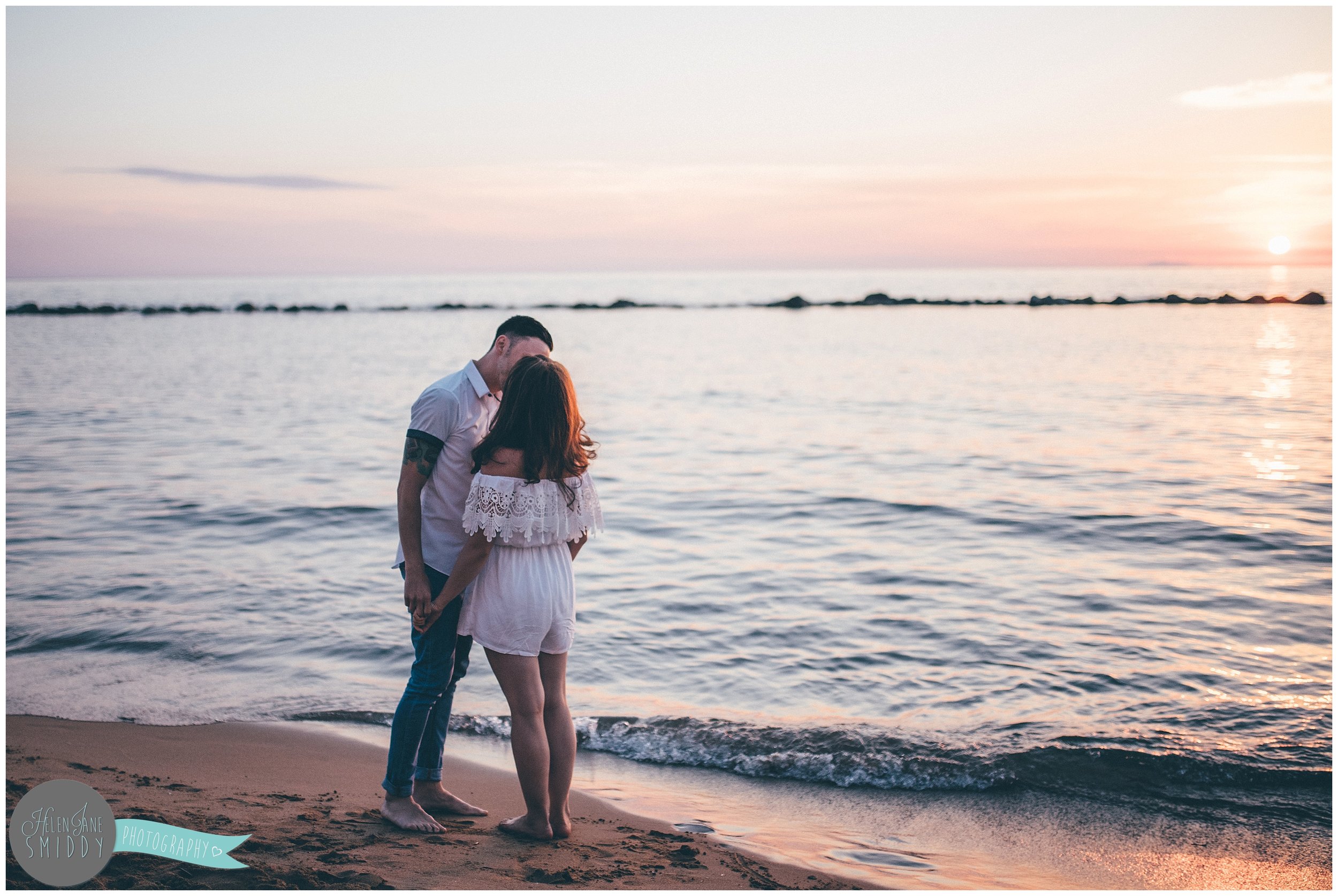 The couple share a kiss at sunset, the night before their wedding.