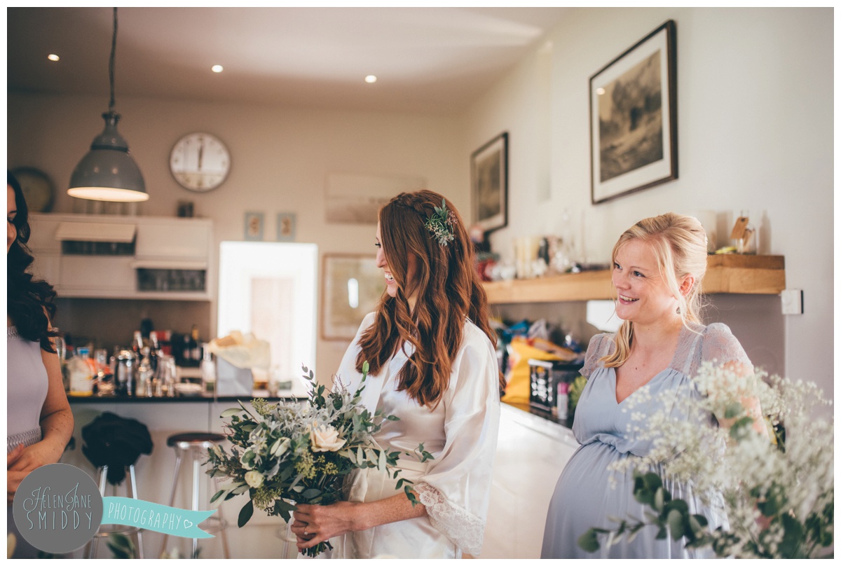 The bride laughs with her bridesmaids at Barn Drift in Norfolk.