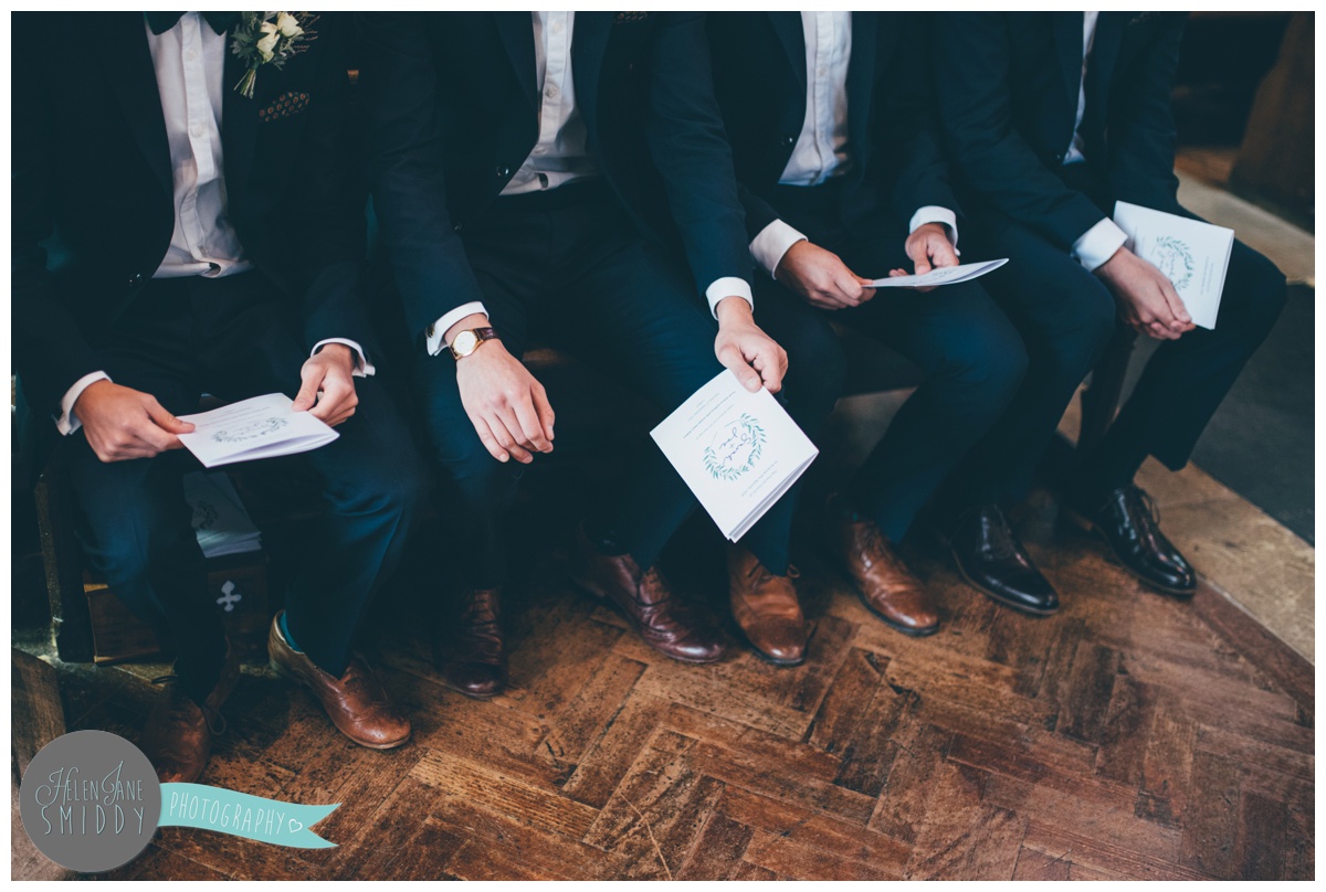 Groomsmen sit and wait for the bride at church.