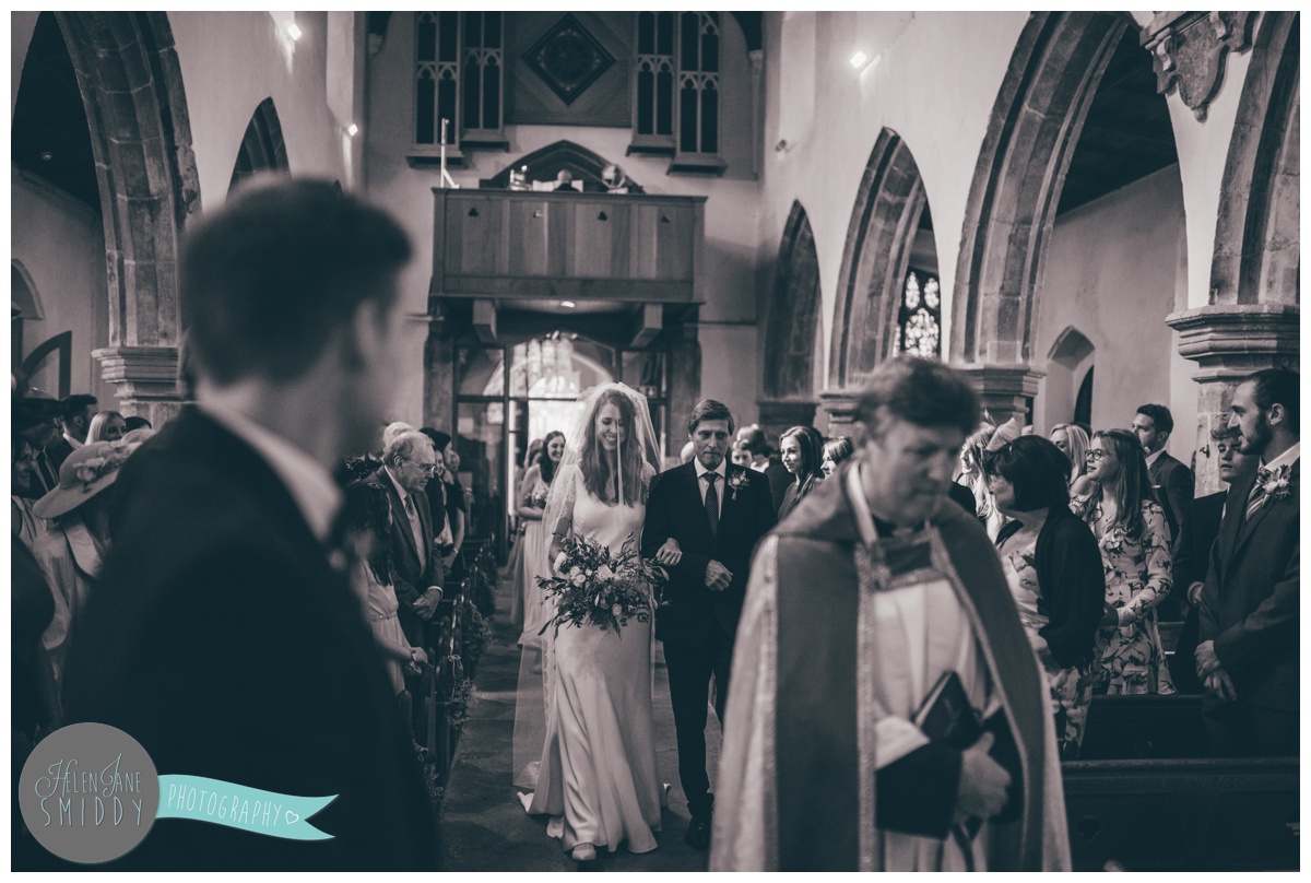 Sarah beams as she walks down the aisle to her husband-to-be.