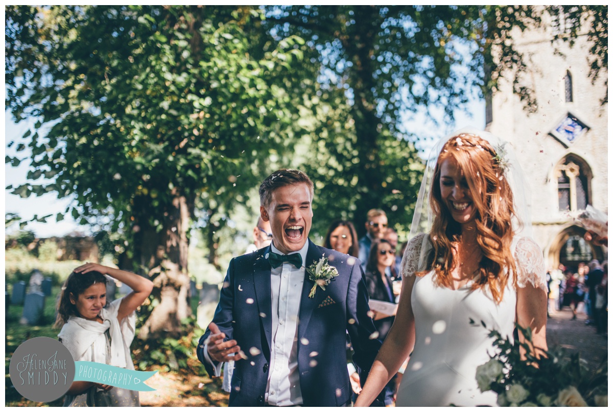 Colourful confetti gets thrown at the bride and groom at their sunny September wedding.