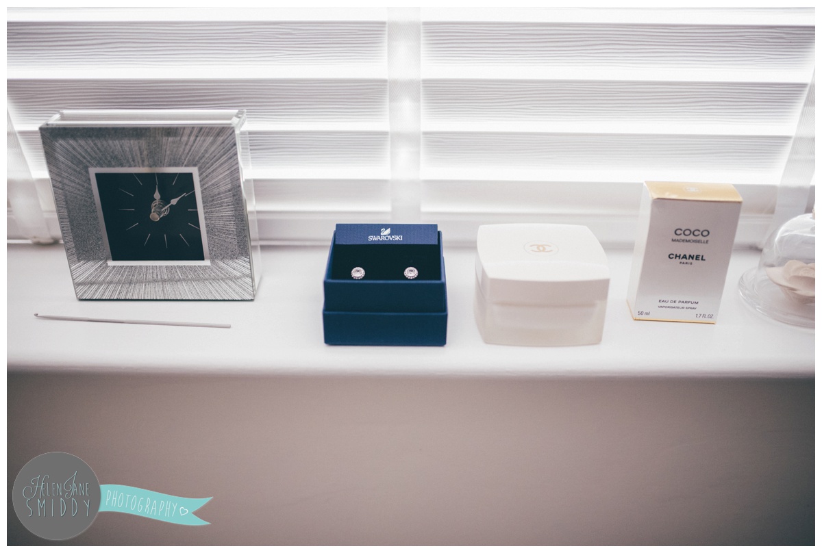 The bride's earrings and perfume on the window sill on her wedding morning.