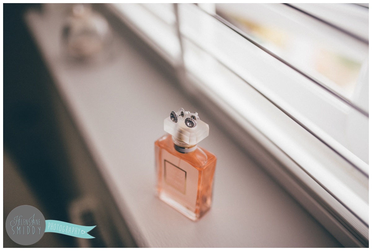 The bride's Swarovski earrings on top of her Chanel perfume bottle.