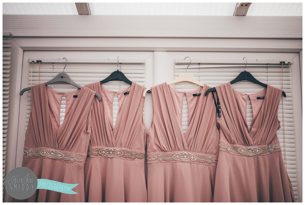 The blush pink bridesmaid dresses hung up on the morning of the wedding.