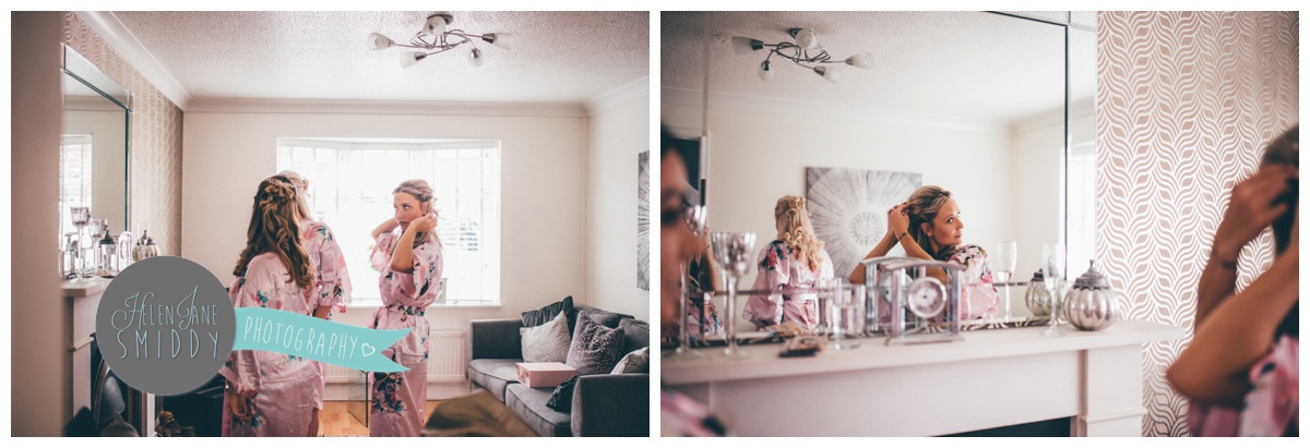 The bridesmaids admire their hair and make-up in the mirror on the wedding morning.