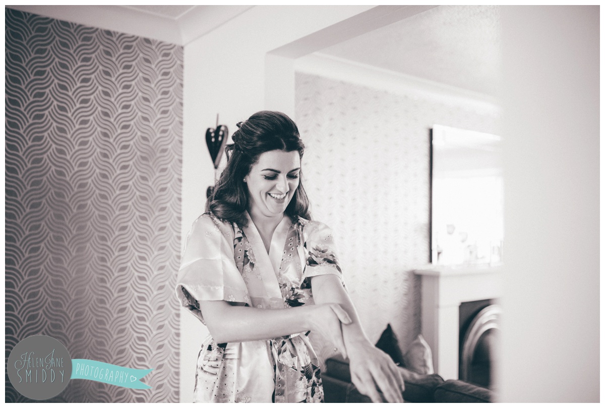 Maid of honour moisturises her arms whilst getting ready for the wedding in Cheshire.