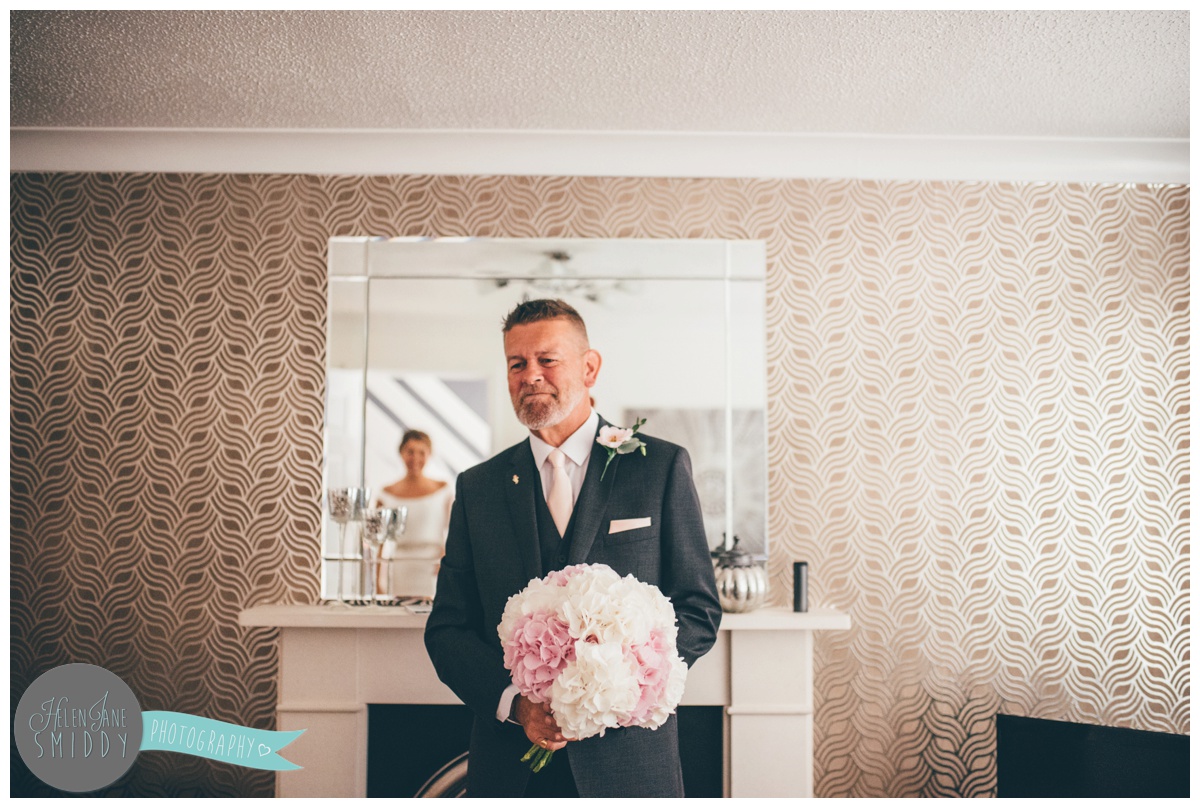 father of the bride sees his daughter in her wedding dress for the first time.