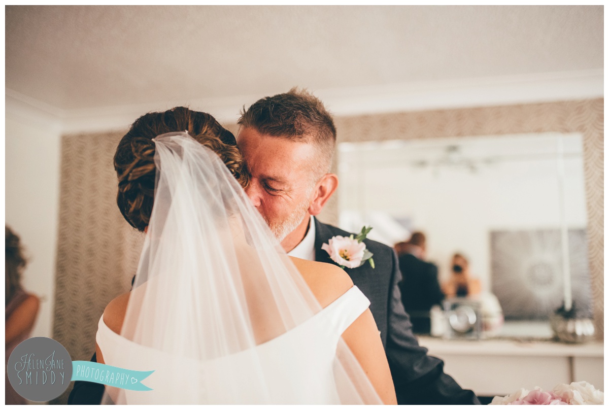 father of the bride sees his daughter in her wedding dress for the first time.