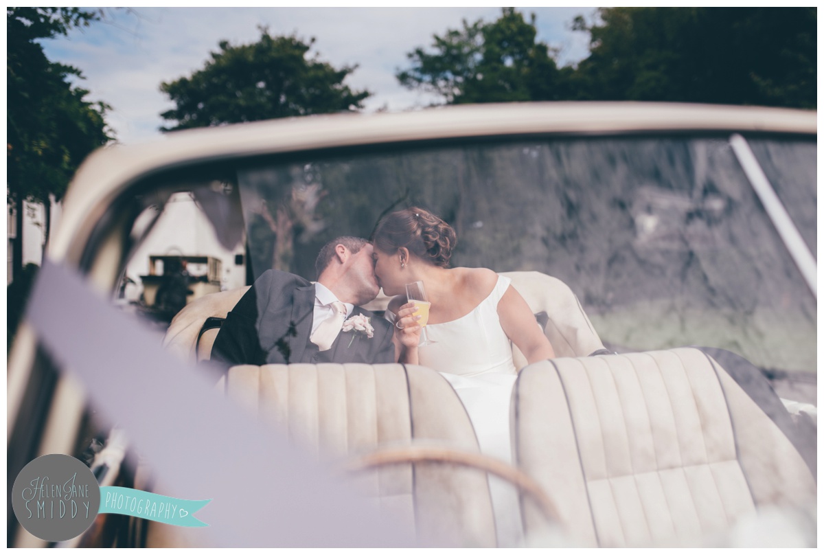 The bride and groom arriving at their wedding venue in their chauffeur driven car.