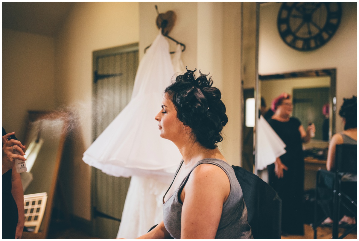 The staffordshire MUA does finishing touches at the bride's face.