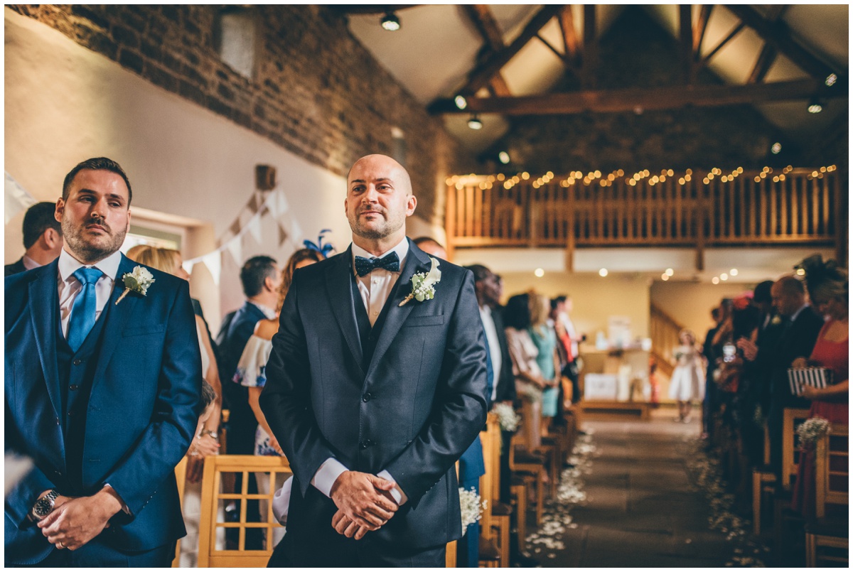 The bridesmaids lead the bride and her father into the ceremony room at The Ashes wedding barn in Staffordshire.