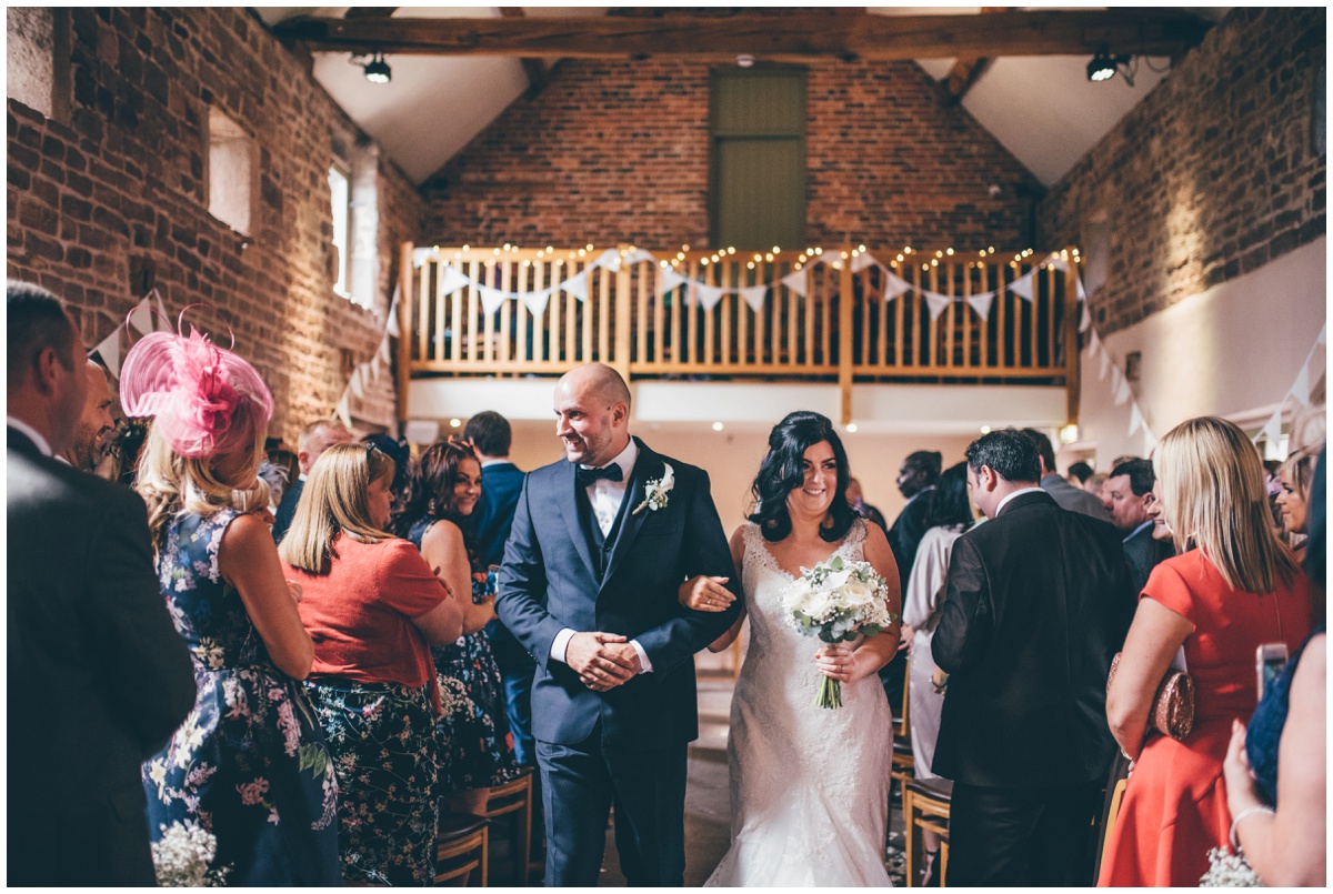 The new husband and wife walk down the aisle together at The Ashes wedding barn in Staffordshire.