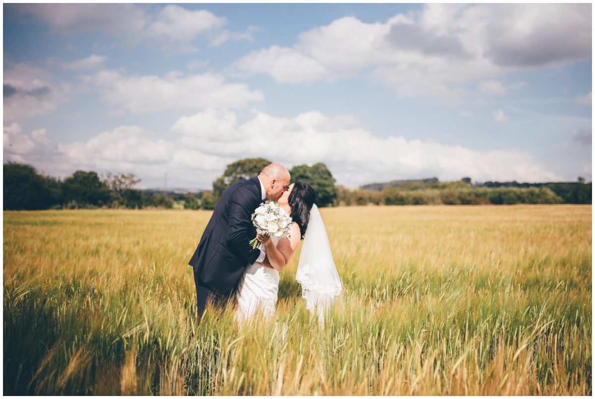 Amy and Phil share a kiss in a cornfield at The Ashes wedding barn in Staffordshire.