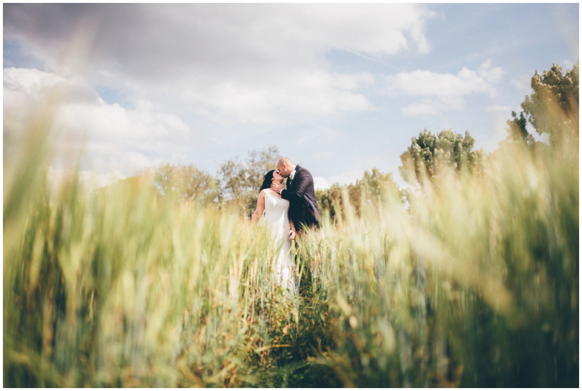 Beautiful symmetrical wedding photograph in a cornfield at The Ashes wedding barn in Staffordshire.