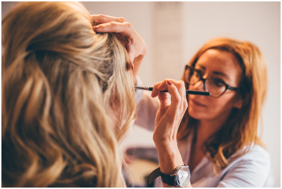 Professional make-up artist concentrates on the bride's eye make-up.