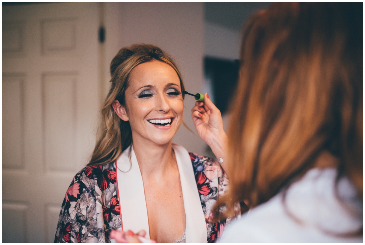 Manchester Bride laughs as the make-up artist makes a joke.