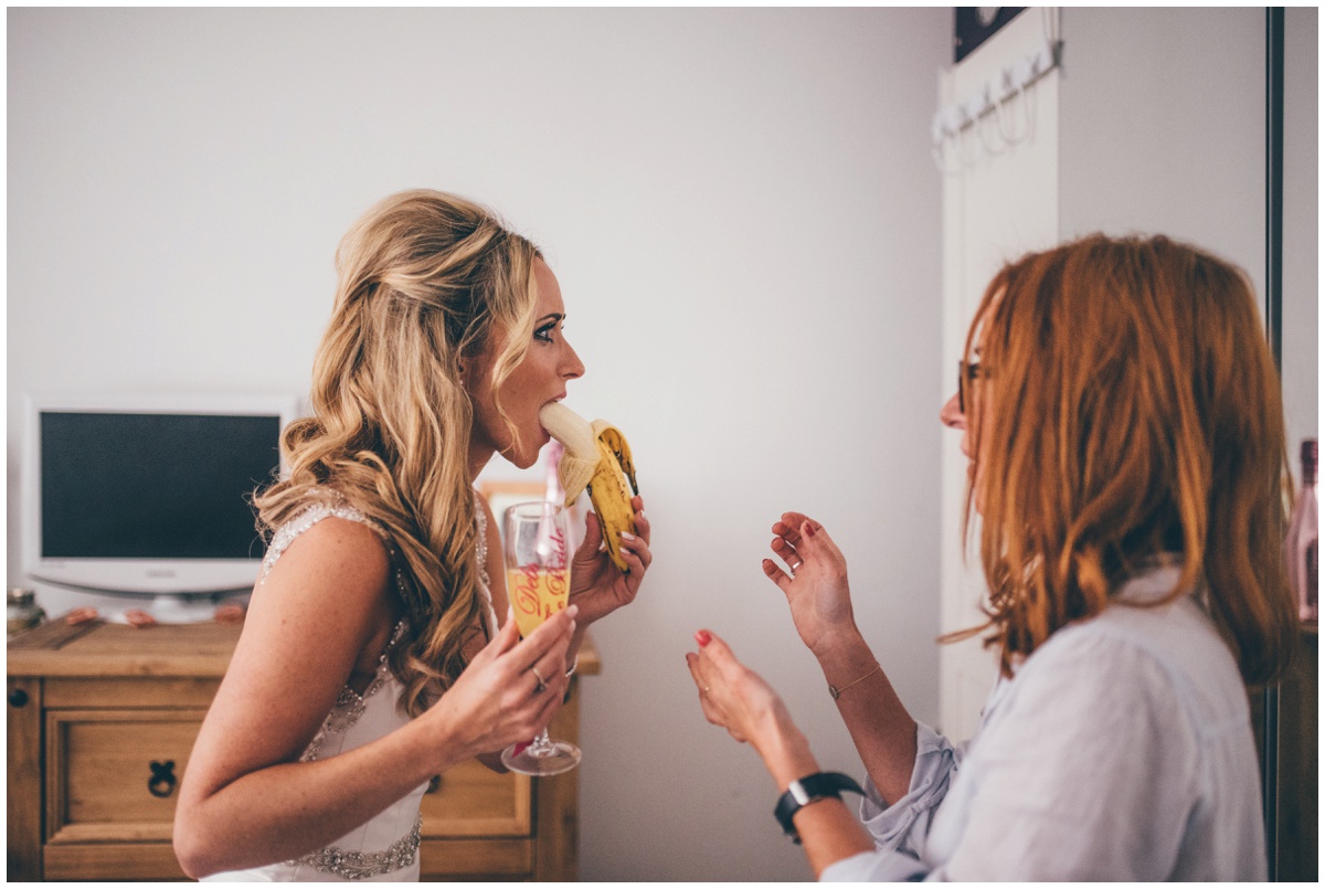 Funny moment of bride eating a banana whilst trying not to ruin her make-up.