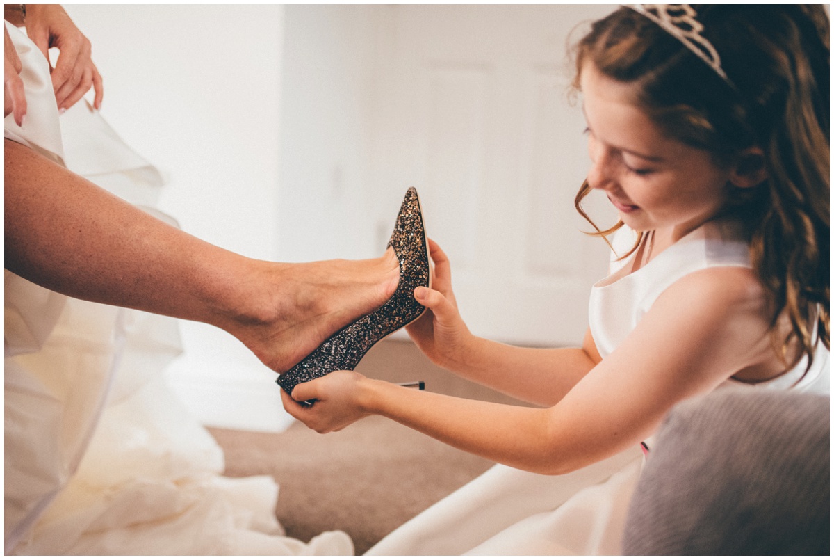 The flowergirl puts on the bride's beautiful Jimmy Choo shoes.