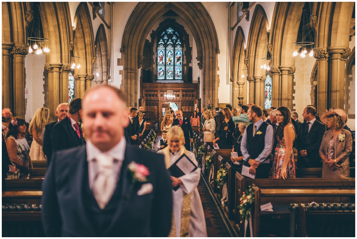 The vicar of St Mark's Church in Worsley leads the bridal party in to the groom.